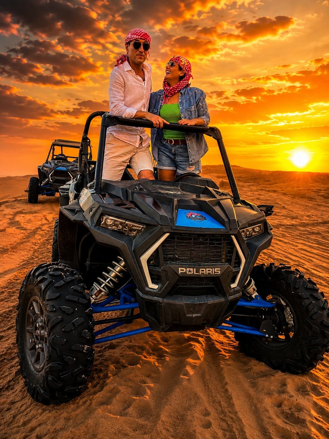 Polaris RZR driving across red dunes in Dubai